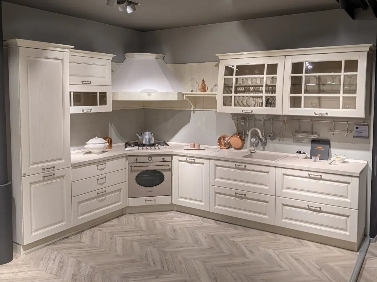 Cucina angolare classica Stosa Bolgheri finitura burro, con vetrine e cappa a camino, nello showroom di Veduggio