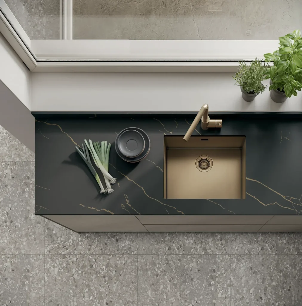 Lavello sottotop color bronzo in un top effetto marmo nero di una cucina Stosa